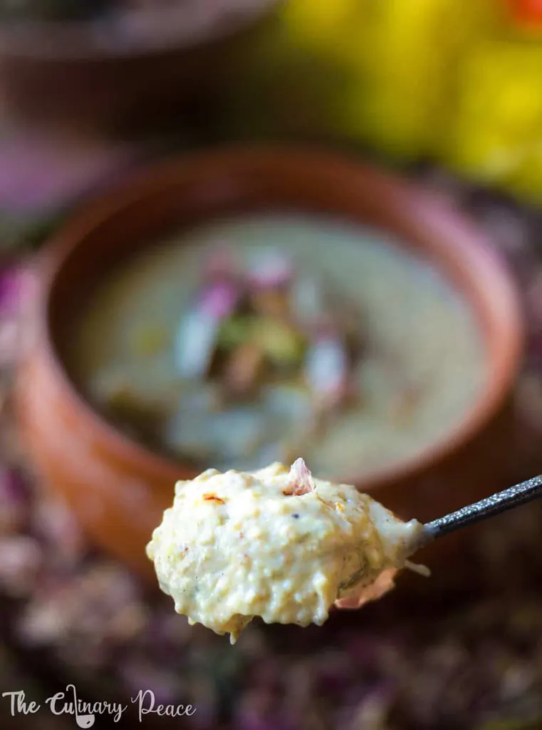 Creamy phirni made with thandai powder served in an earthen pot against holi colors. It is a holi festival sweet.